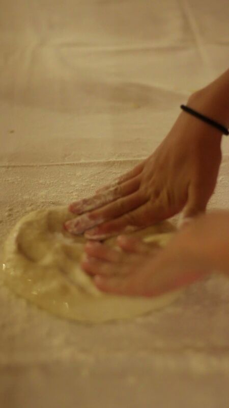Hands kneading dough on table
