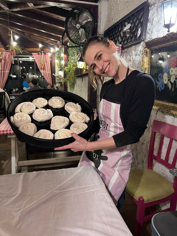 Guest proudly showing a tray of handmade burek